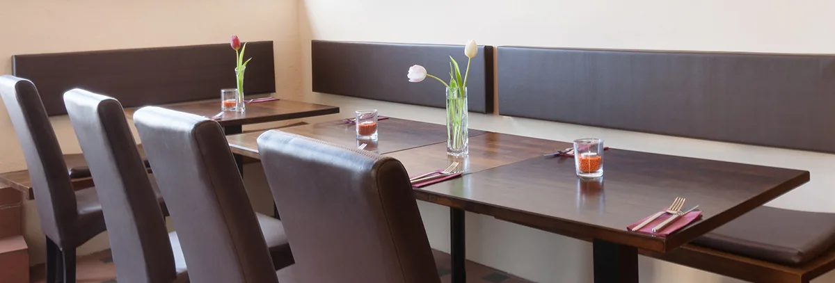 Gedeckte Tische mit Lederbank und Tulpen