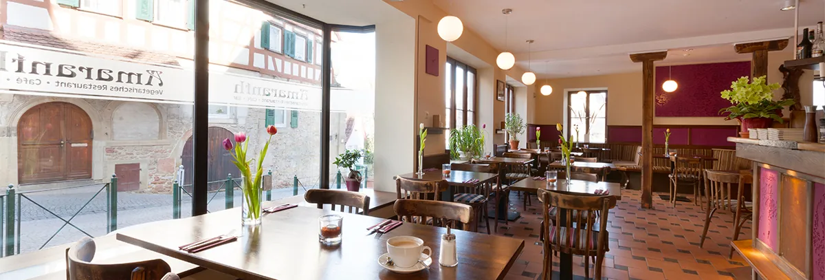 Heller Gastraum des Amaranth mit Blick durch das Fenster auf ein Fachwerkhaus in der Marbacher Altstadt